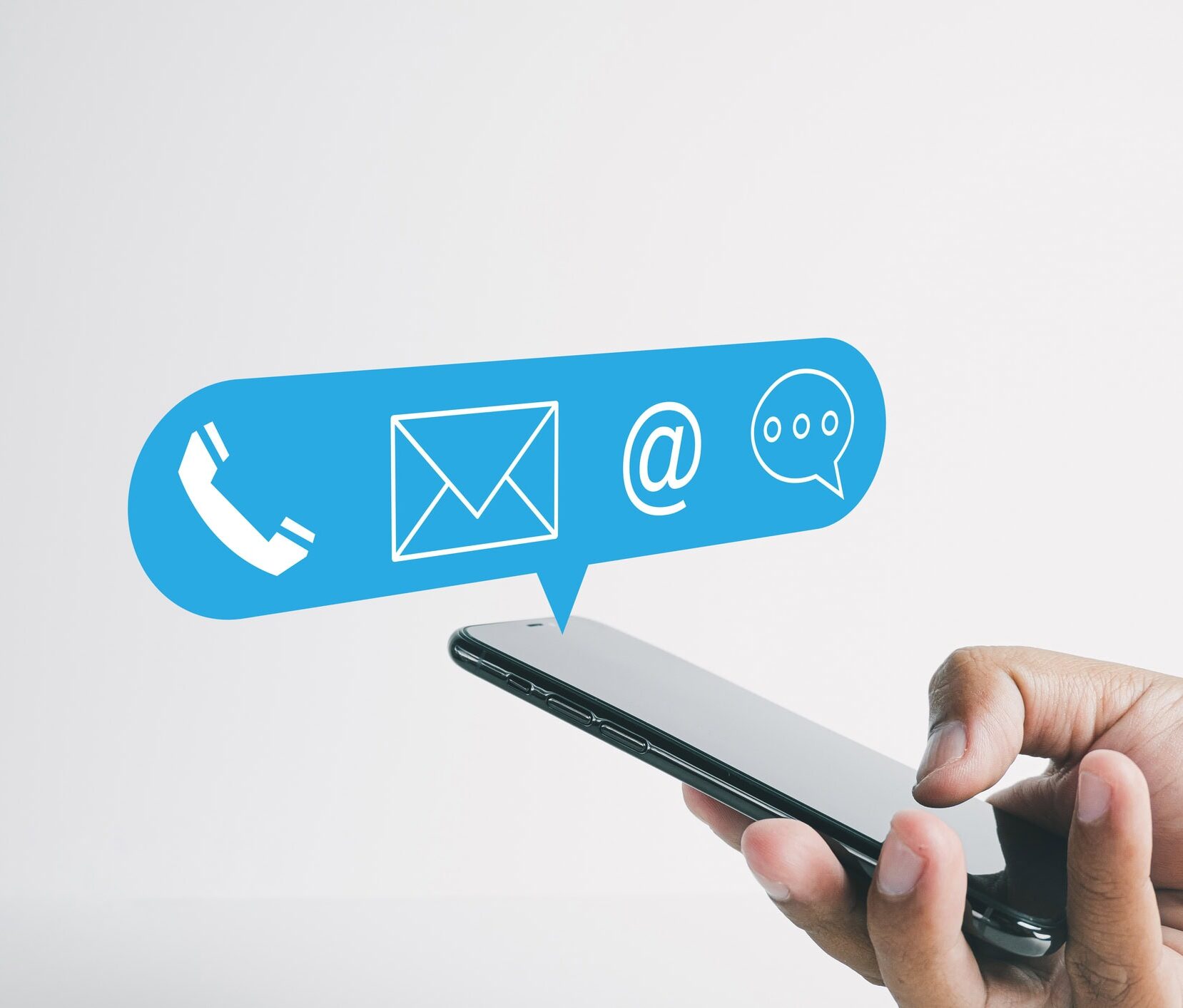 Hand using smartphone with Contact Us icon in speech bubble