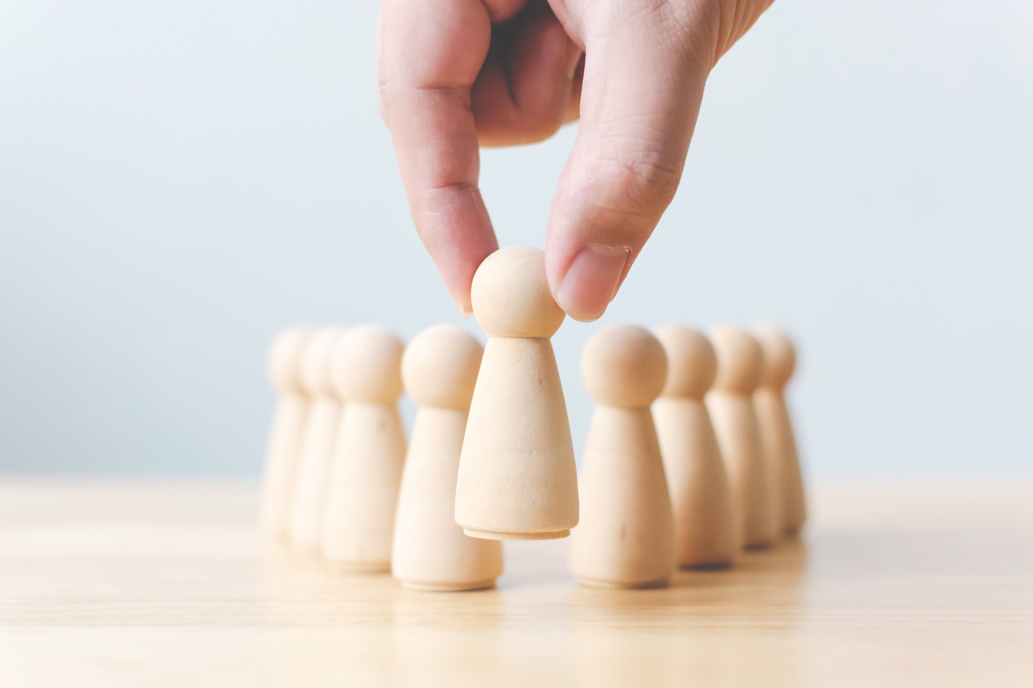 Human resource, Talent management, Recruitment employee, Successful business team leader concept. Hand chooses a wooden people standing out from the crowd.